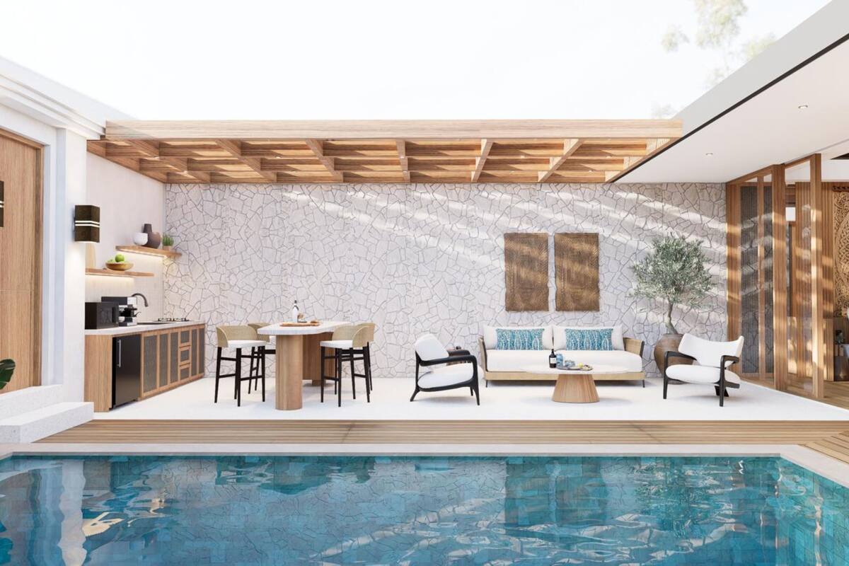 A modern outdoor living area with a pool, wooden pergola, stone wall, and seating arrangements.