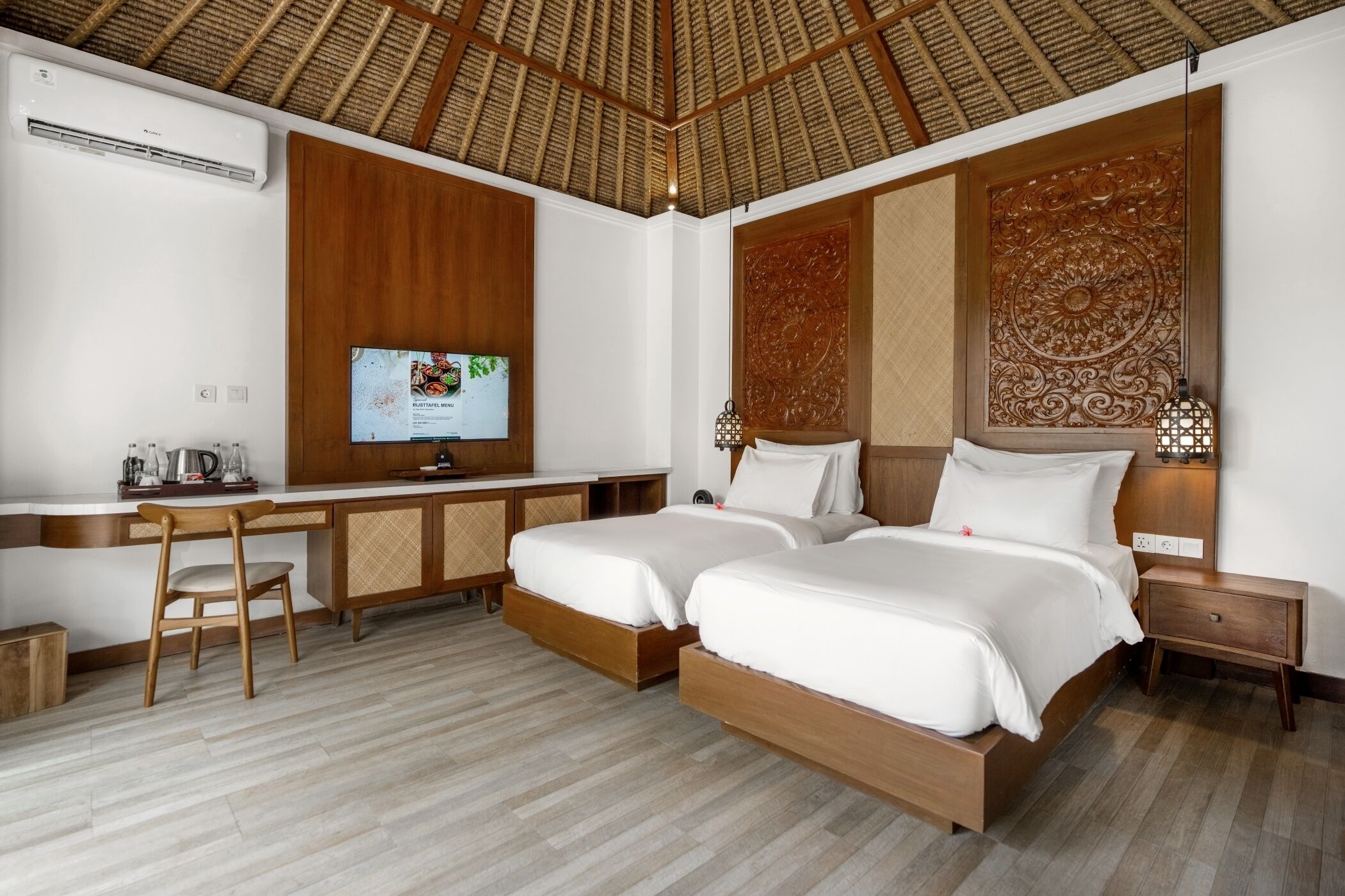 Una habitación de hotel con dos camas, un escritorio, una silla y un televisor.