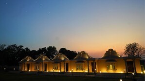 Una serie de estructuras con forma de templos, con múltiples cúpulas pequeñas y una gran luna en el cielo.