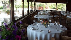 A restaurant with round tables set for dining, featuring white tablecloths and floral centerpieces. - Hotel Villaggio Torre San Vito (Gaeta)