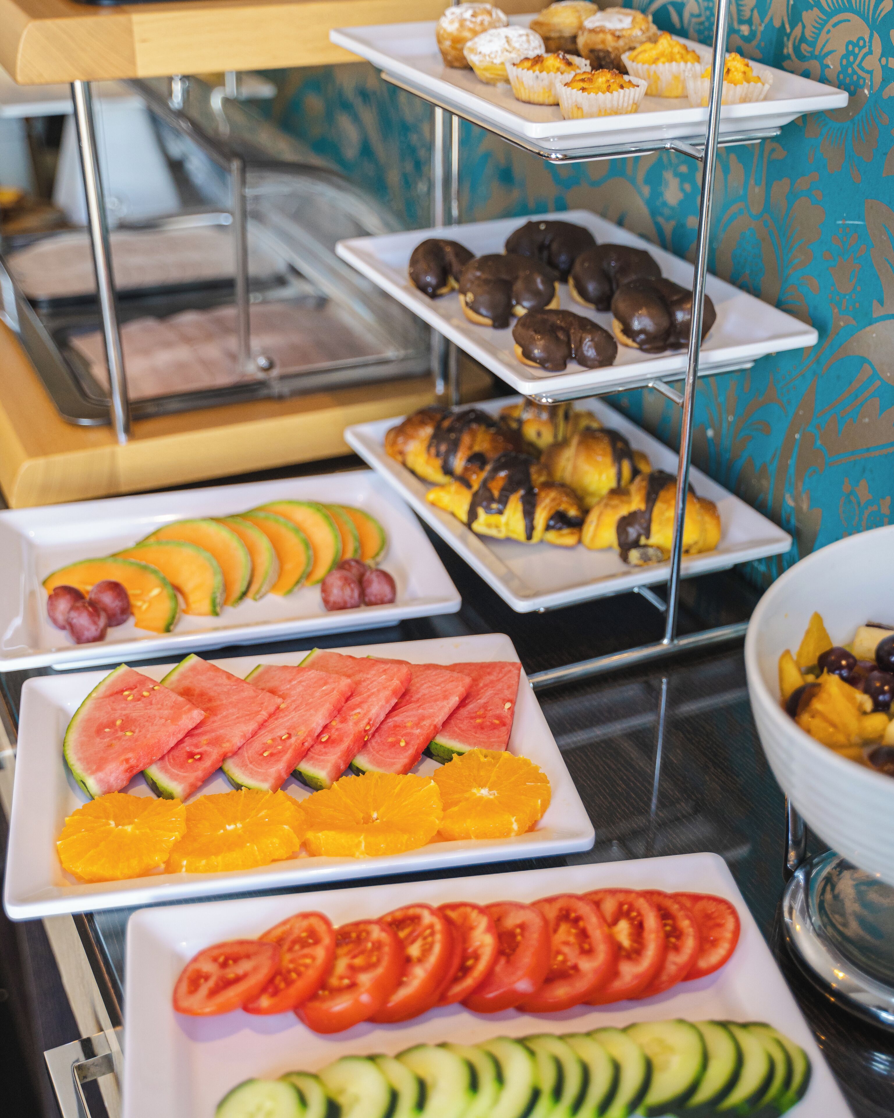 Ein reichhaltiges Buffet mit verschiedenen Speisen, darunter Gebäck, Obst und Gemüse.