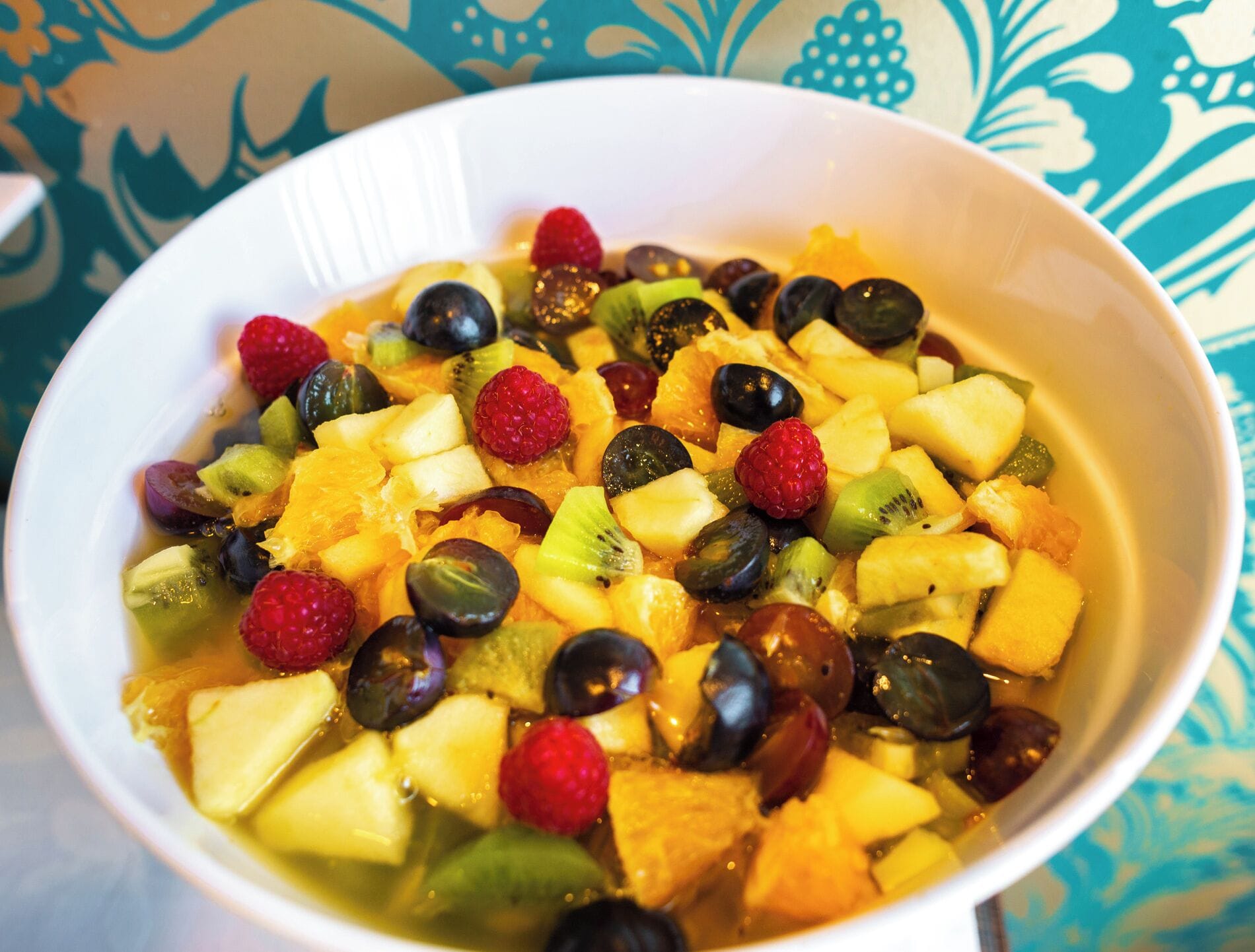 Eine Schüssel Obstsalat mit verschiedenen Früchten und Flüssigkeit.