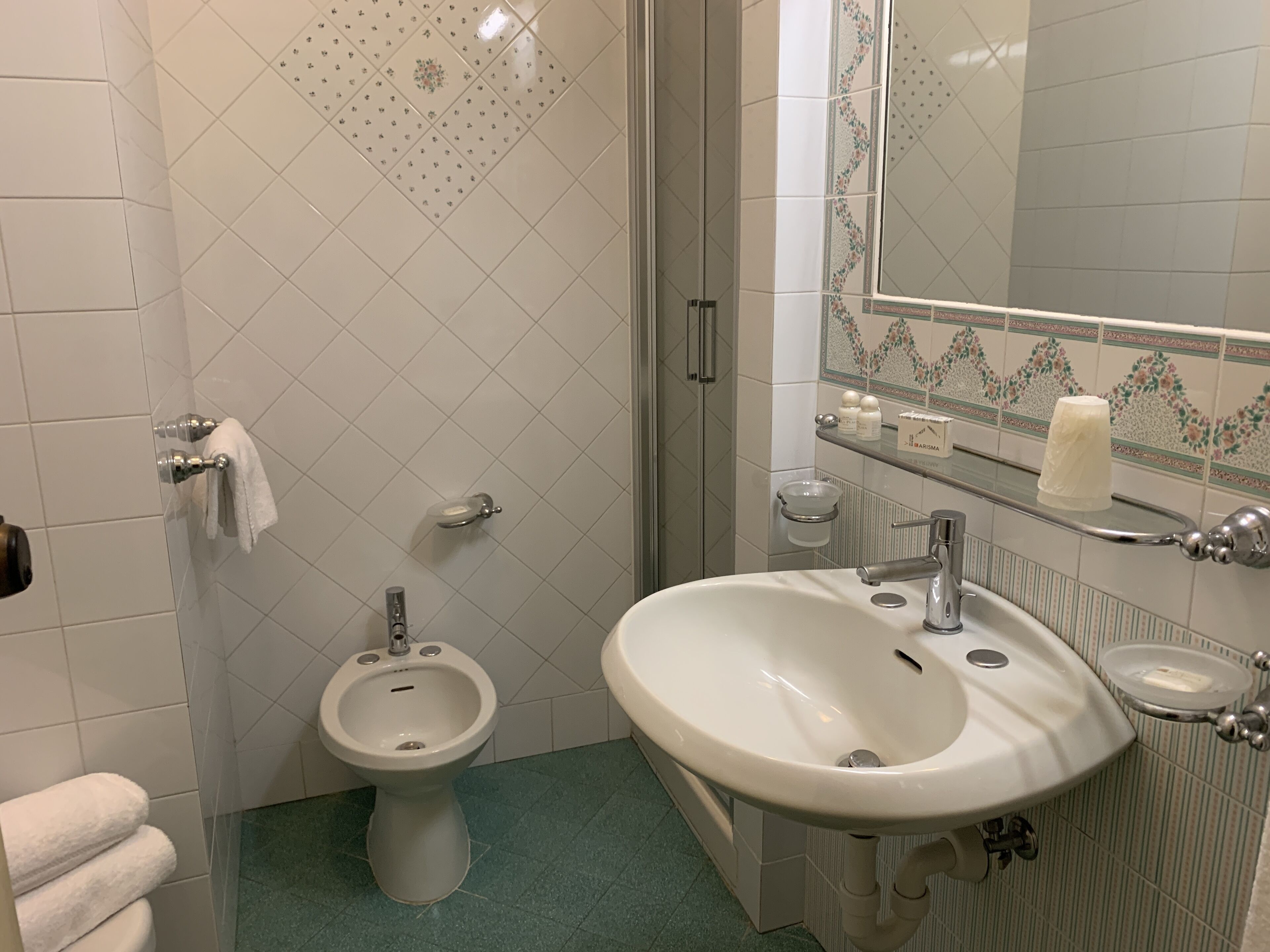 Un bagno con bidet, lavandino, specchio e WC.