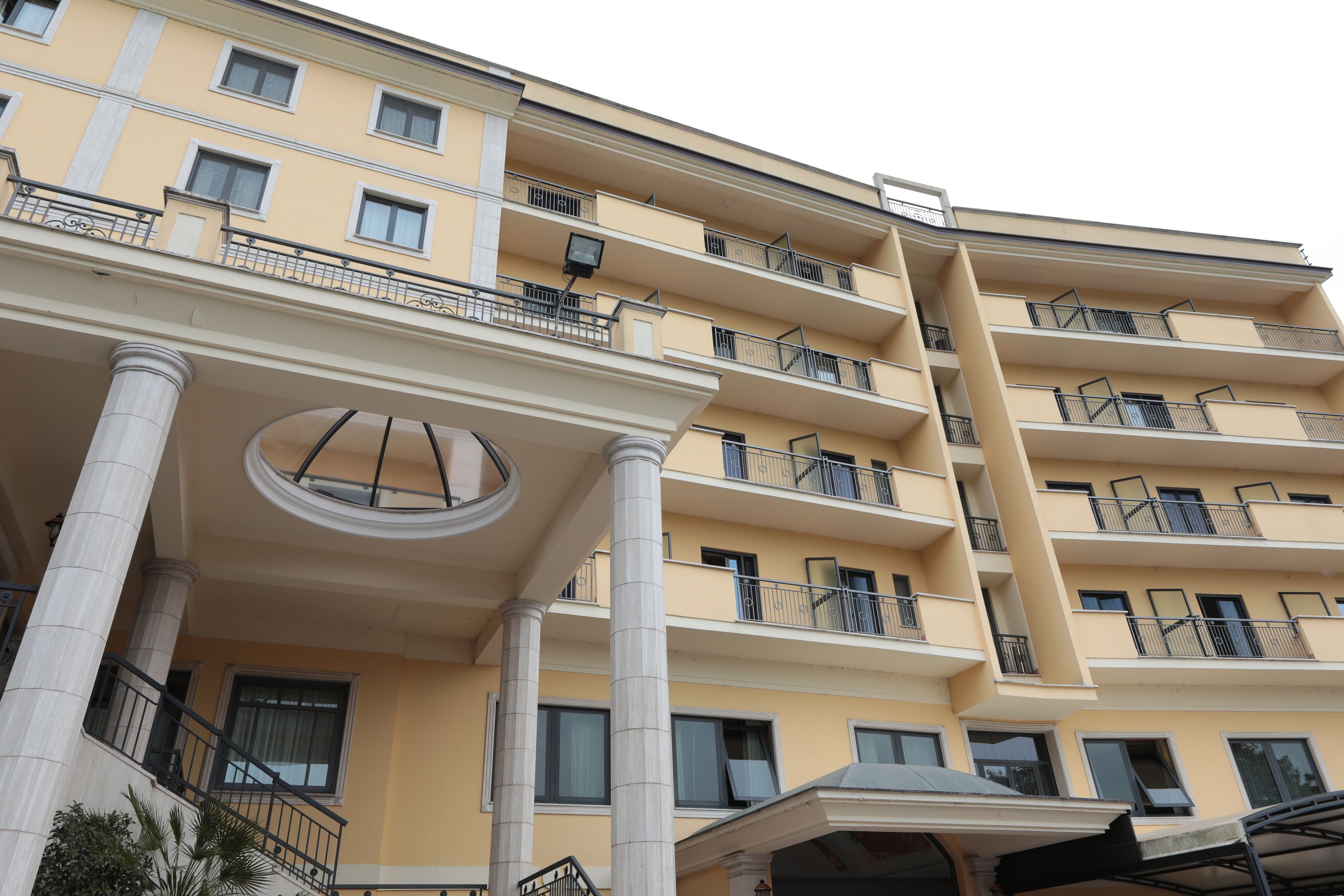 Un hôtel à plusieurs étages, doté de balcons, de grandes fenêtres et d’une structure circulaire centrale.