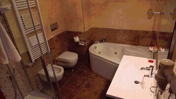 Ein Badezimmer mit Duschkabine, Toilette, Badewanne und Waschbecken.