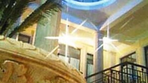 Un vestíbulo con una gran fuente decorativa, una escalera y un techo alto con tragaluces.