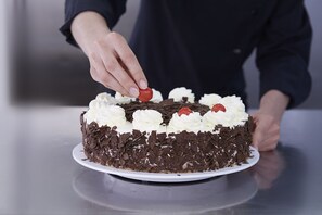 A cake with whipped cream and chocolate shavings on a white plate. - Hotel Beek (Baden-Baden)