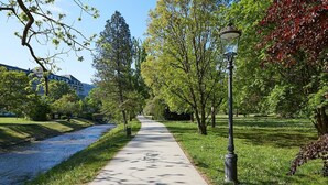 A paved pathway in a park with trees and a lamp post. - Hotel Beek (Baden-Baden)