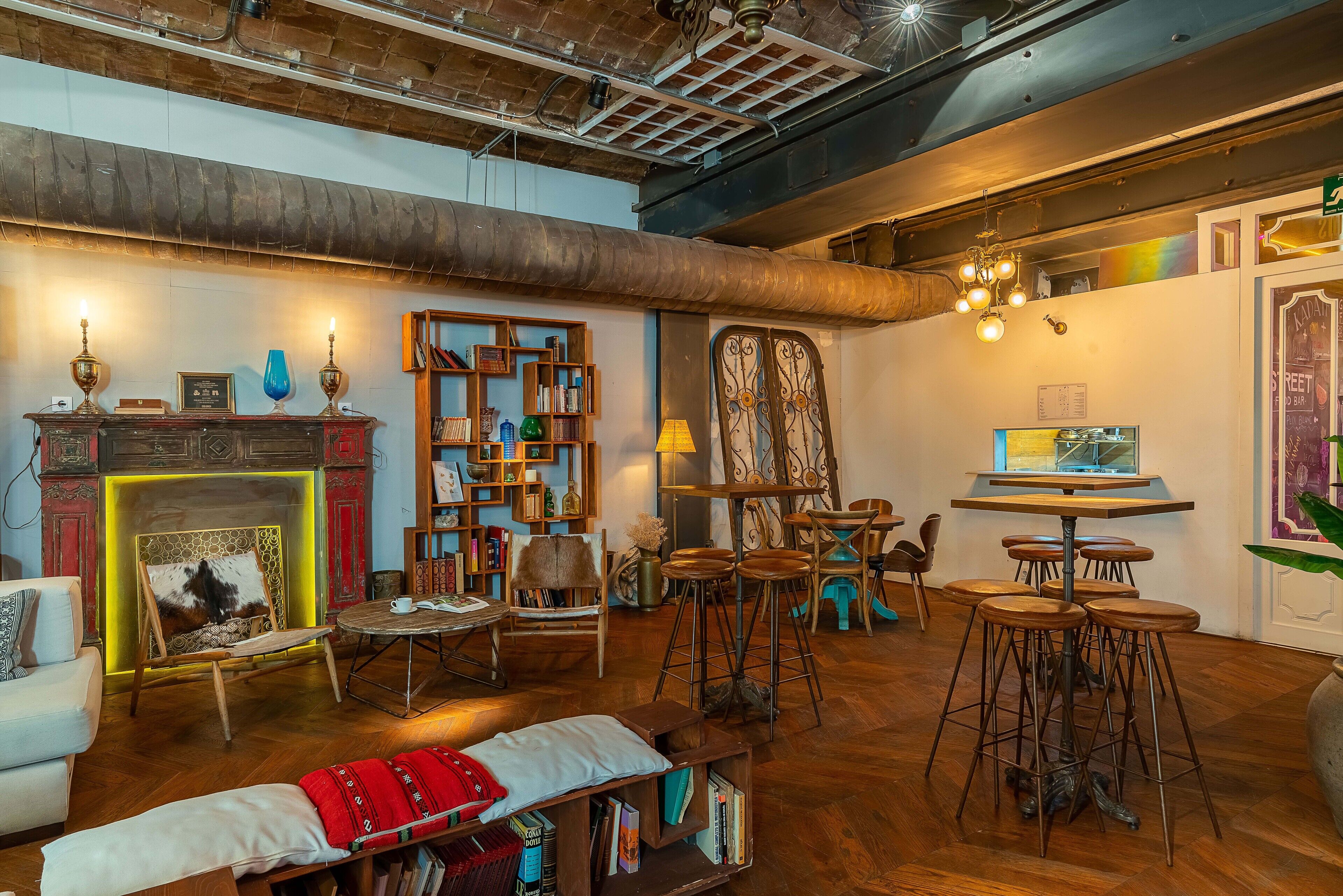 Una habitación acogedora y bien iluminada con chimenea, estanterías, comedor y bar.