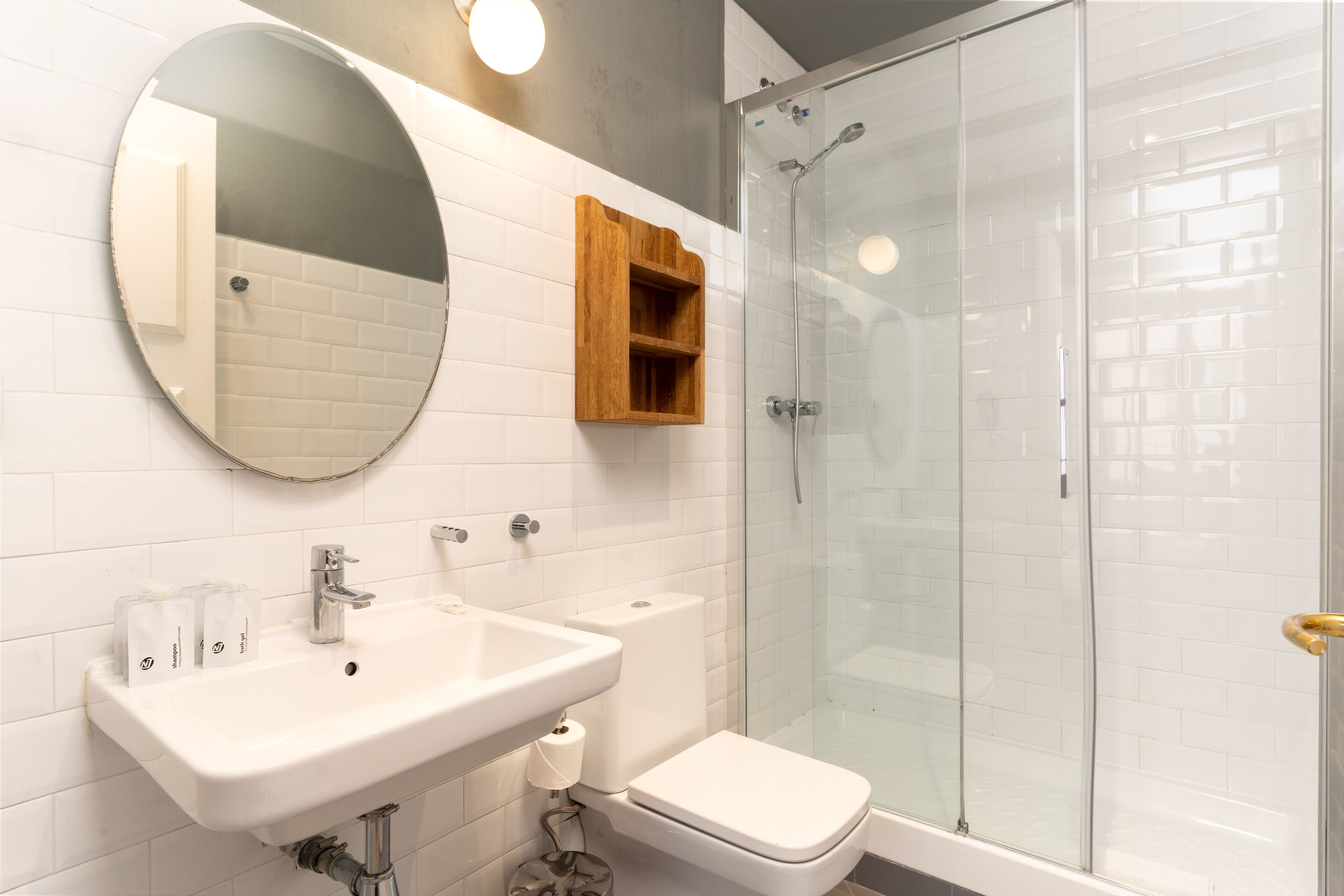 A bathroom with a sink, toilet, and glass shower enclosure.