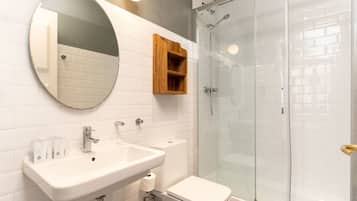 A bathroom with a sink, toilet, and glass shower enclosure.