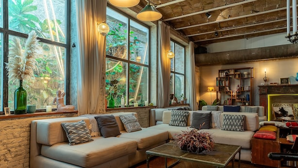 A cozy living room with a sofa, coffee table, and a bookshelf.