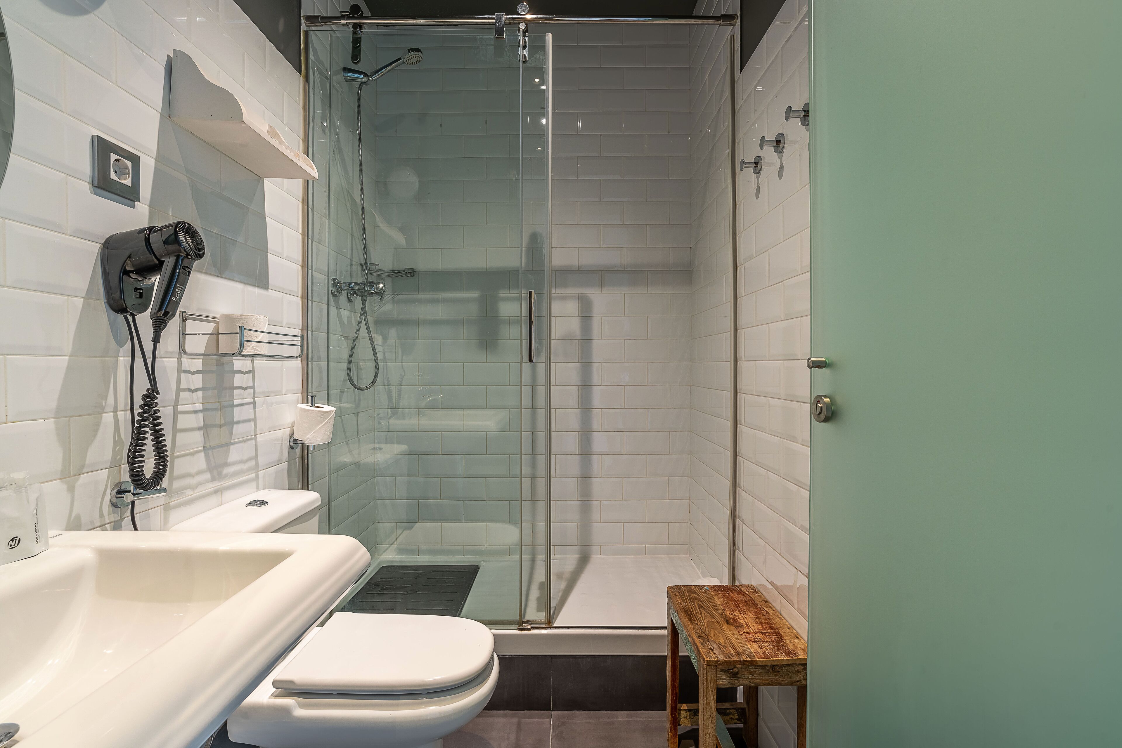 Un baño moderno con ducha envuelta en vidrio, un lavabo blanco y un inodoro.