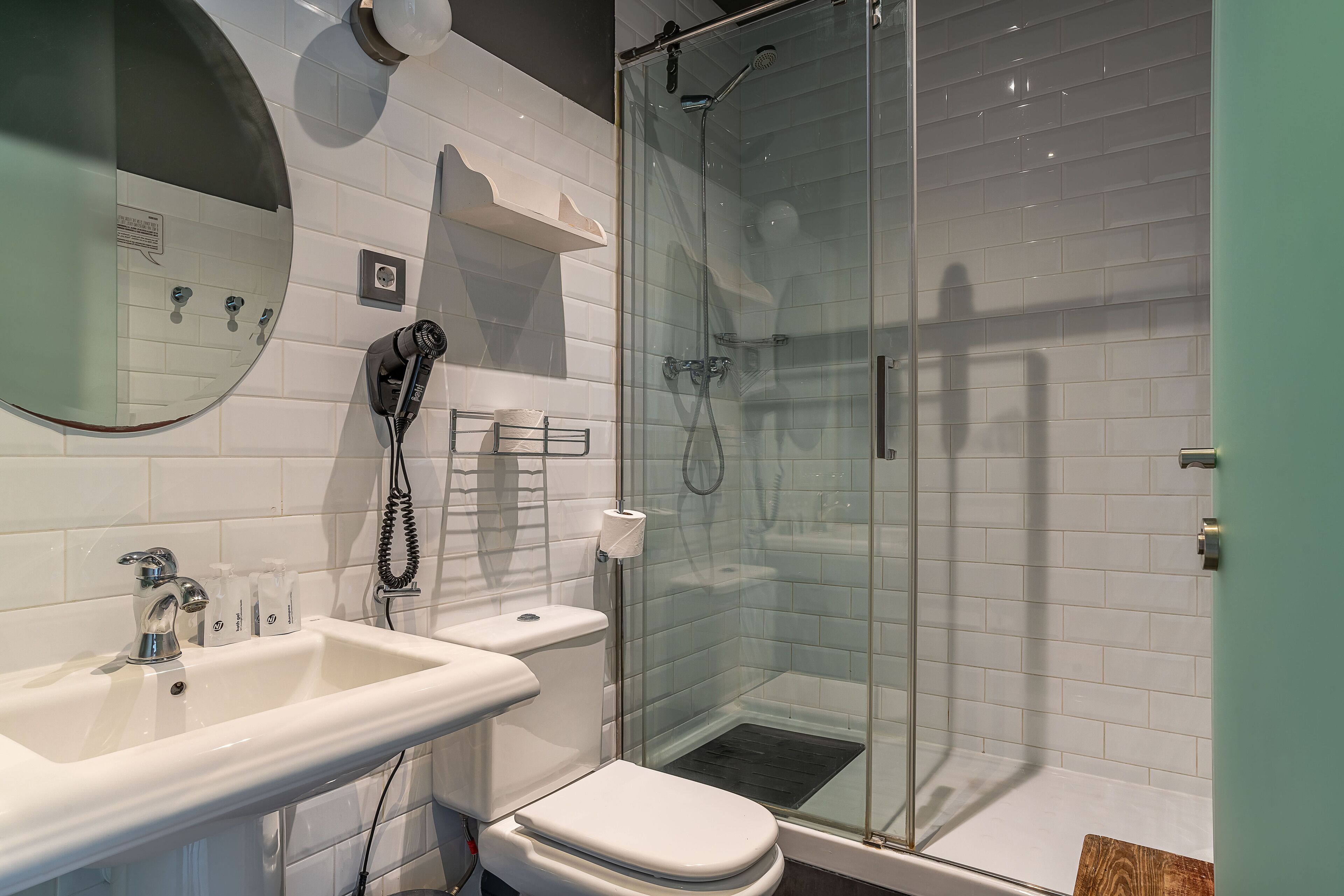 A modern bathroom with a glass-enclosed shower, a sink, and a toilet.