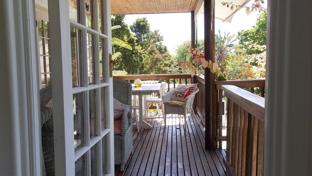 A wooden deck with a railing, a bench, and a table.