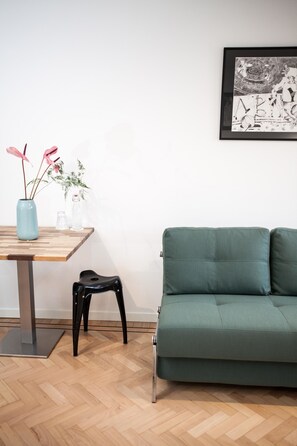 Deluxe vierpersoonskamer, 1 queensize bed met slaapbank, balkon, uitzicht op de stad | Woonruimte