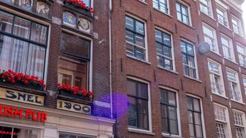 A row of brick buildings with storefronts, including a pub and a shop with a visible door number.