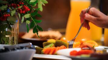 Een ontbijttafel met verschillende soorten fruit en een glas sinaasappelsap.
