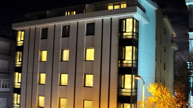 Ein modernes Hotel mit einer glatten Fassade, zahlreichen Fenstern und einem gut beleuchteten Eingangsbereich.