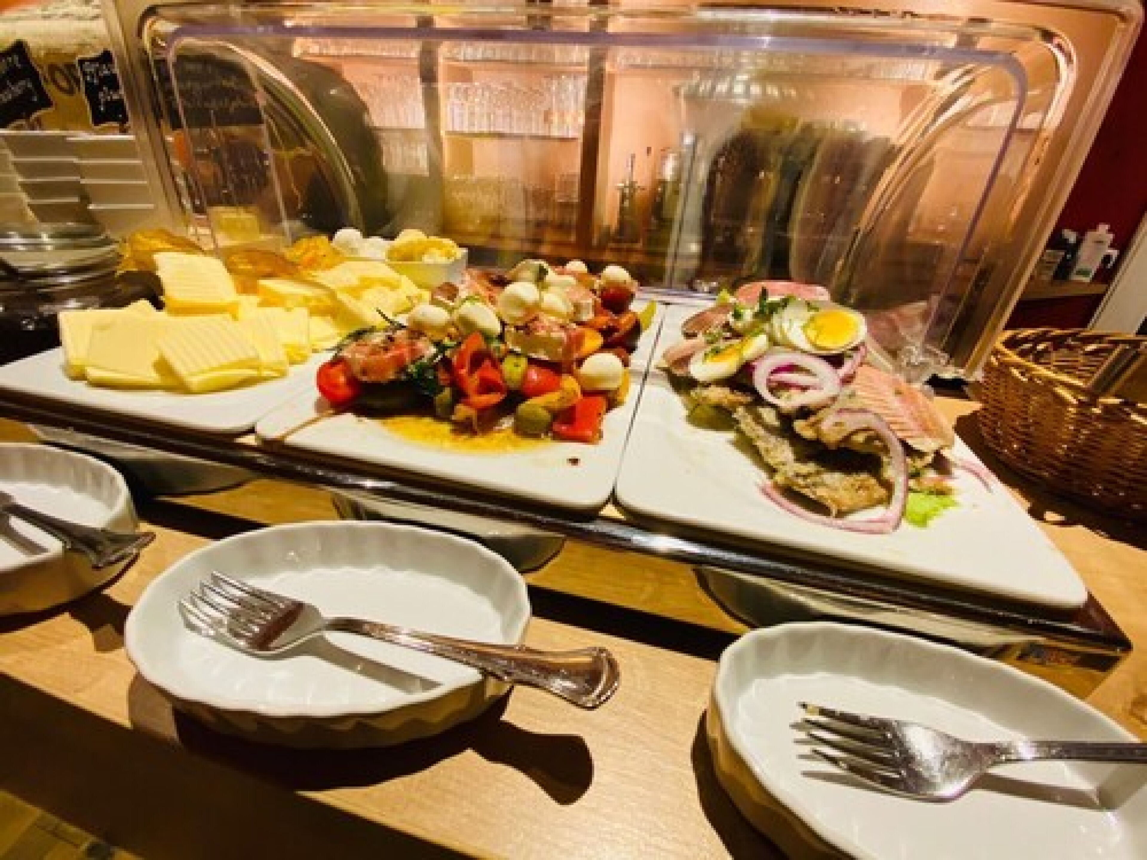Ein reichhaltiges Buffet mit verschiedenen Speisen, darunter Käse, Salaten und Fleisch.