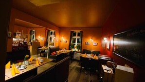 Un restaurante con poca luz, muebles de madera e iluminación cálida.