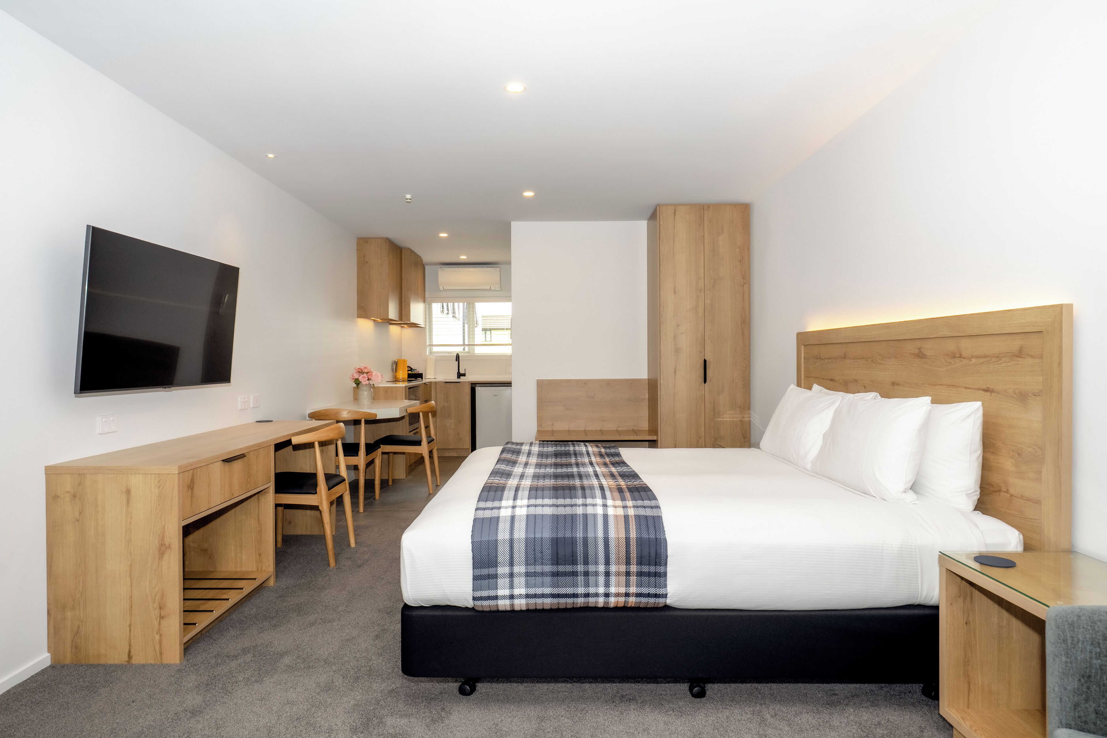 Une chambre d’hôtel moderne équipée d’un lit, d’un bureau et d’une télévision.
