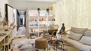 A cozy living room with a sofa, chairs, a coffee table, and a bookshelf filled with items. - Palm Tree Hotel, Best Western Signature Collection (Trelleborg)