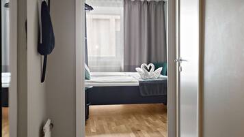 Un dormitorio con cama, radiador, cortina y puerta.