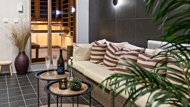 A modern living room with a sofa, two round tables, and a large vase. - Palm Tree Hotel, Best Western Signature Collection (Trelleborg)