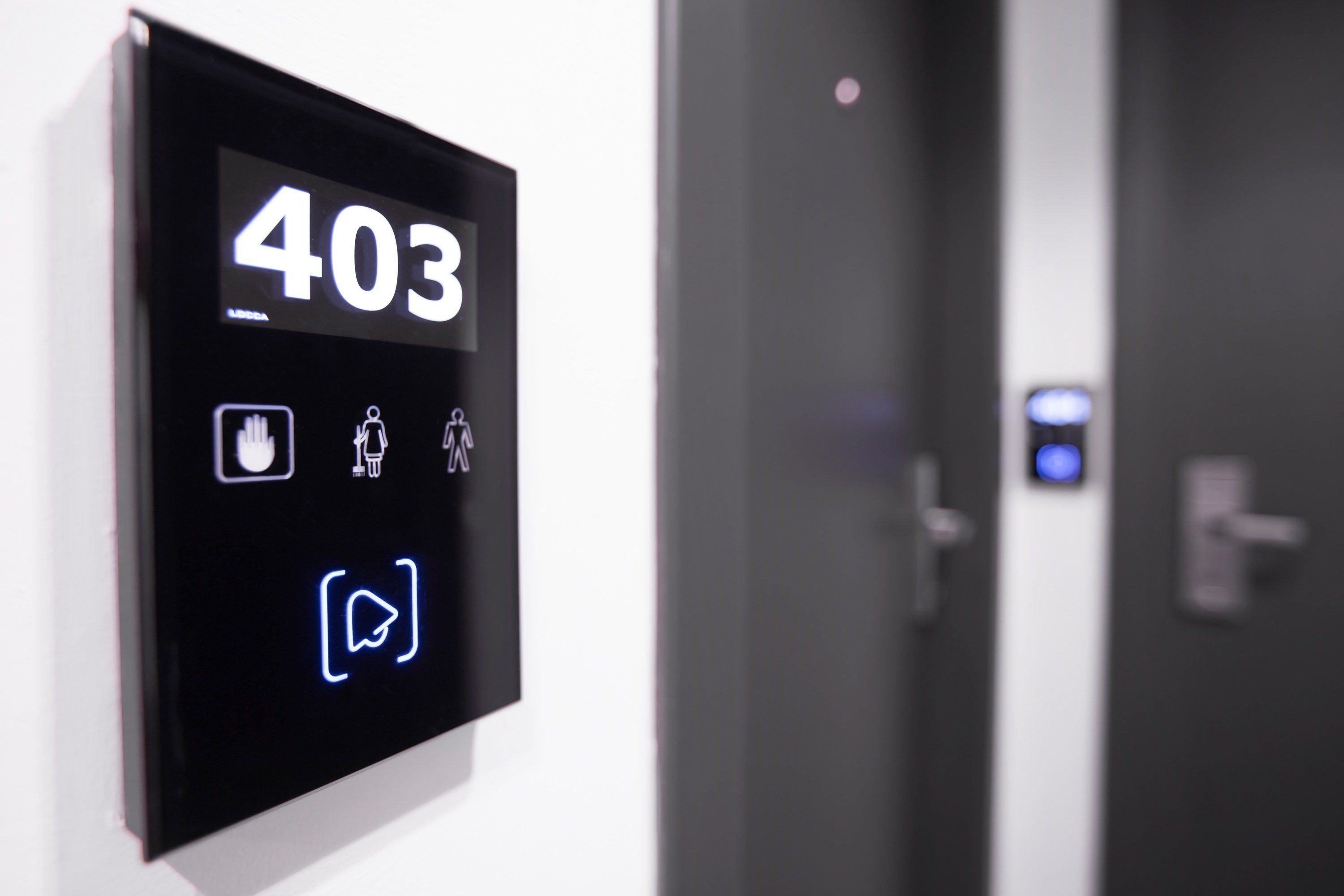 A digital display with the number 403 on a hotel room door, indicating room number.