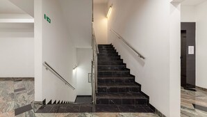 Una escalera con escalones y barandillas de mármol que conduce a un piso superior.
