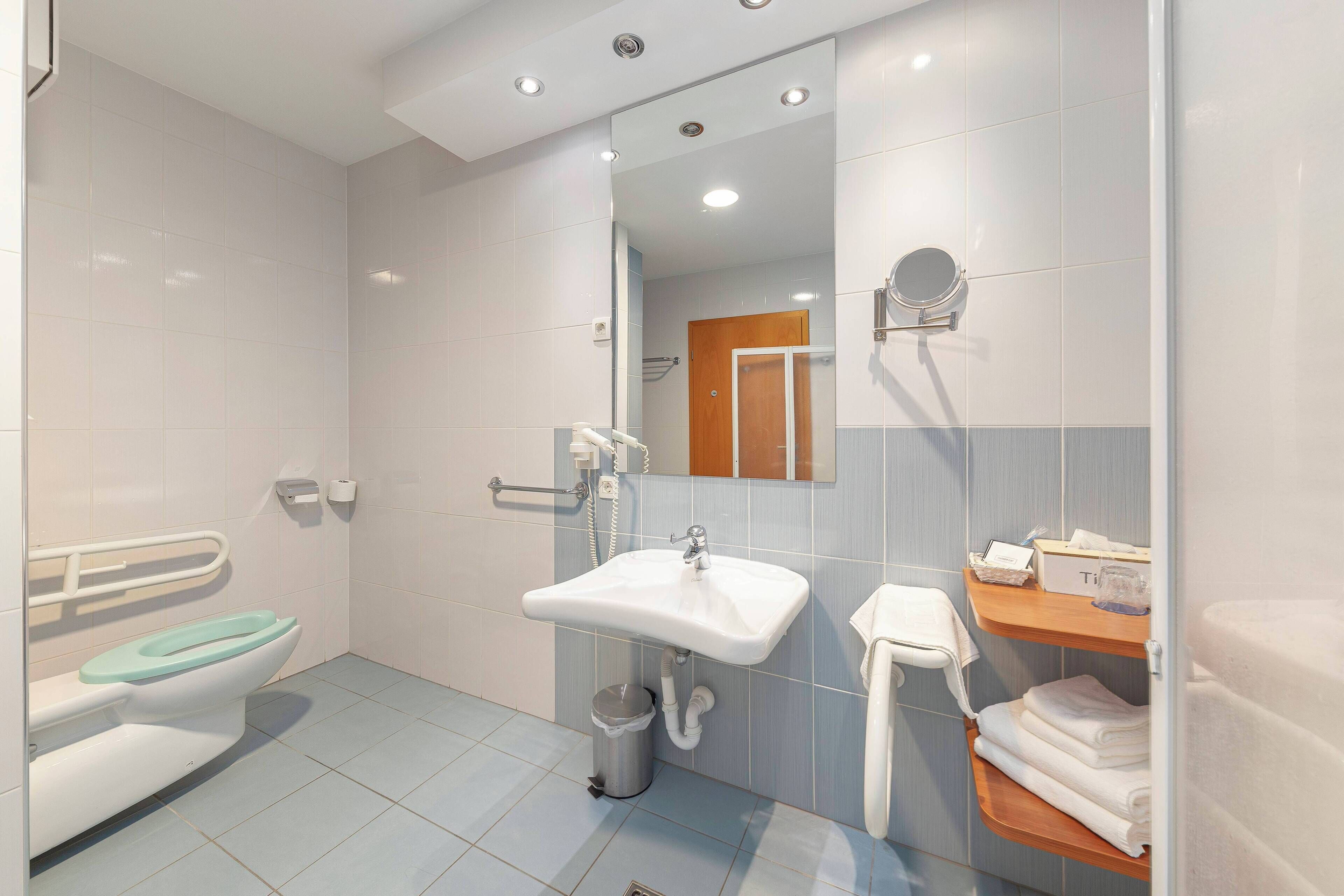 Une salle de bain moderne équipée de toilettes, d’un lavabo et d’une zone douche.