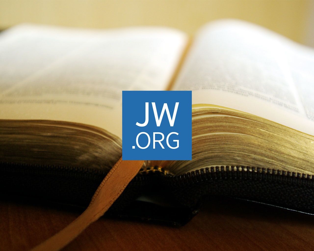 An open book with a bookmark, and the website address JW.ORG is visible on the page.