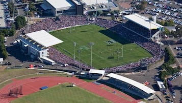 An aerial view of a stadium with a running track, a football field, and spectator stands.