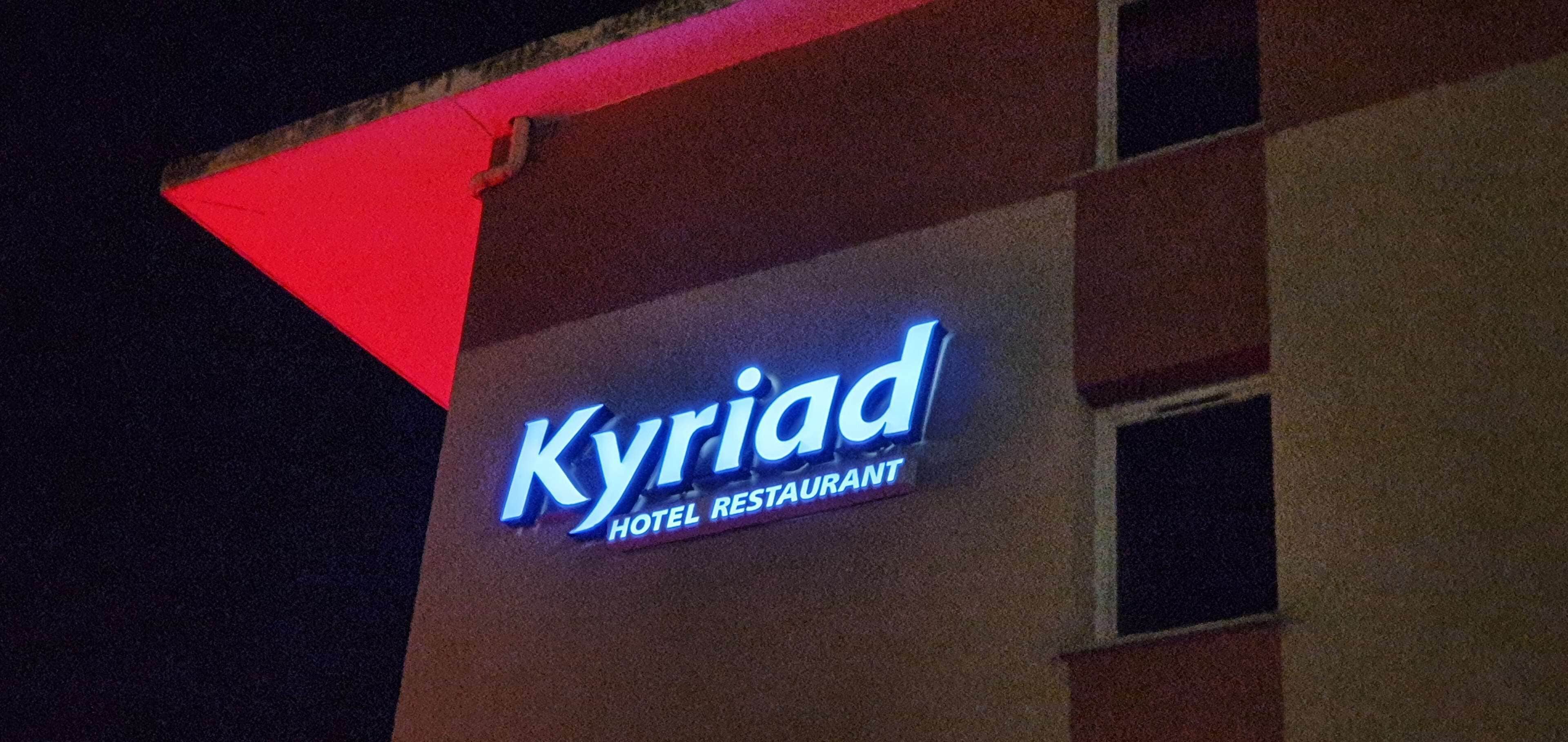 A building with a sign that reads "Kyriad Hotel Restaurant".