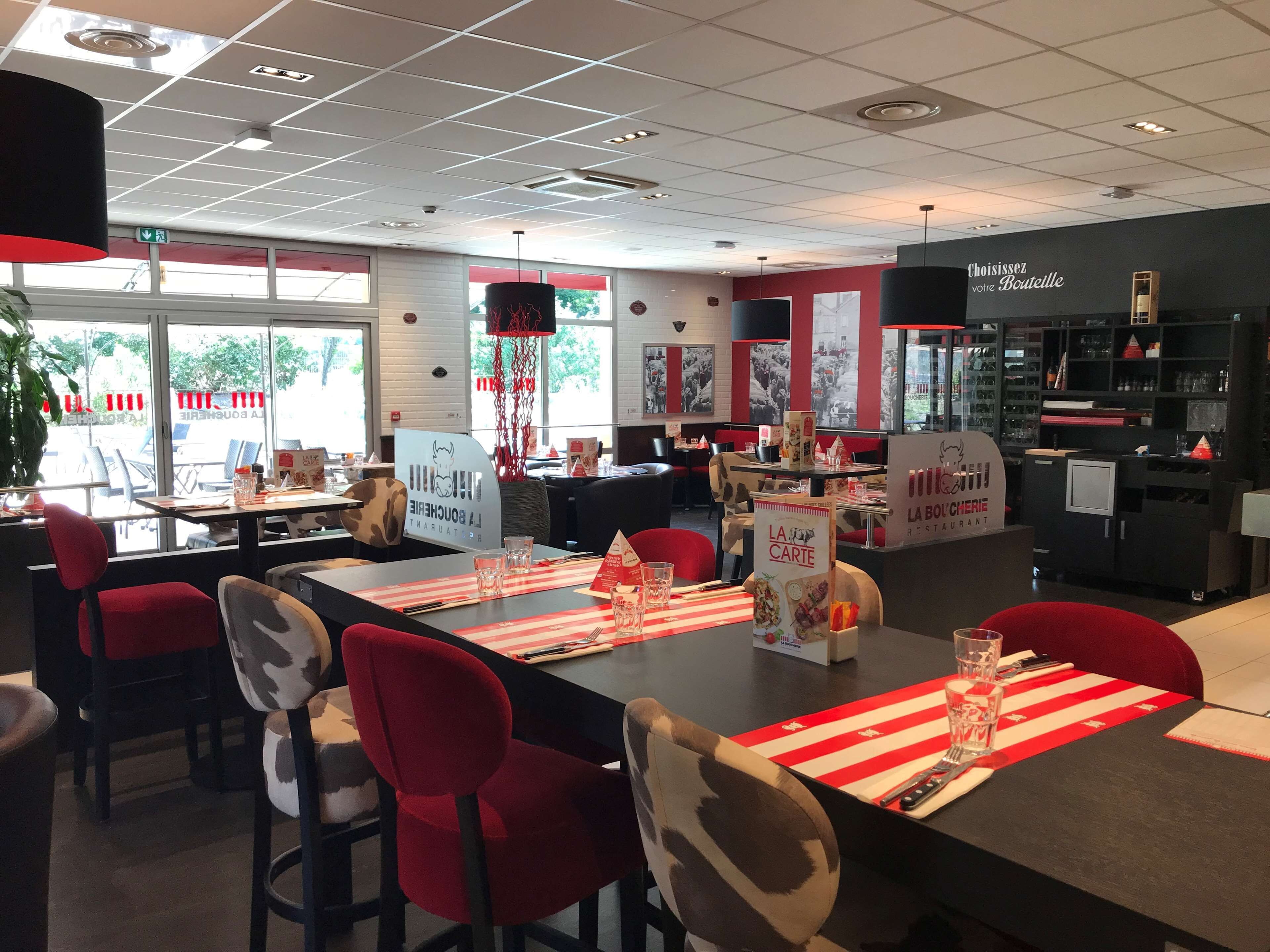 A restaurant interior with tables set for dining, chairs, and a counter area.