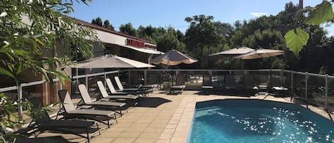 Piscine extérieure, parasols de plage, chaises longues