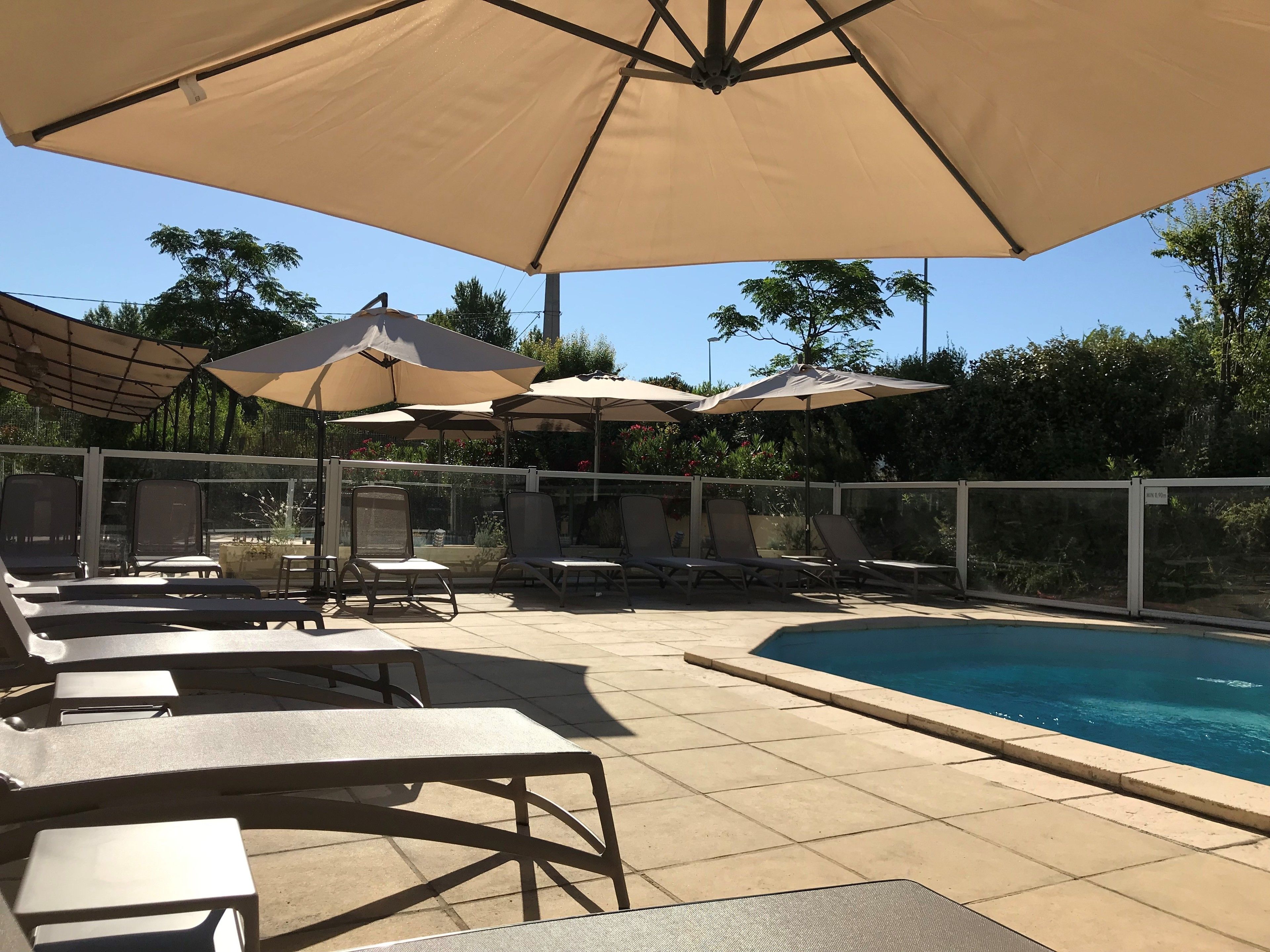 Alberca al aire libre, sombrillas en la alberca y camastros 