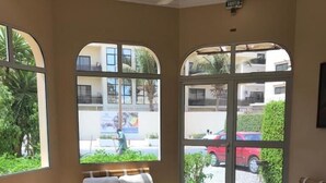 Una habitación con ventanas arqueadas grandes, un ventilador de techo y un cartel que dice 'SORTIE'.