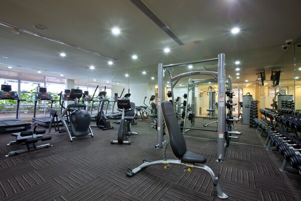 A gym with various exercise equipment, including treadmills, weight machines, and free weights. - PARKROYAL Serviced Suites Kuala Lumpur (Kuala Lumpur)