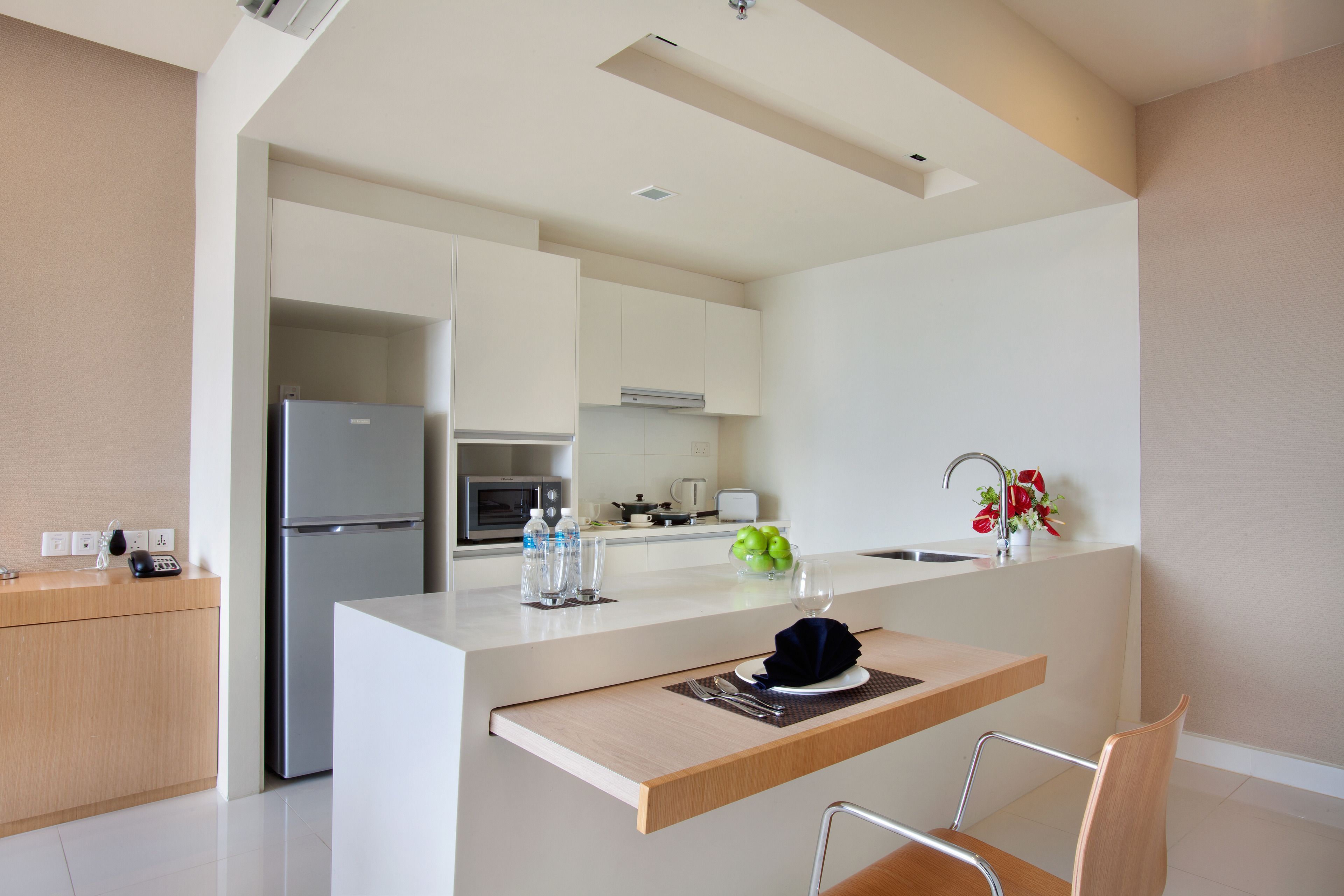 Una cucina moderna con isola centrale, elettrodomestici in acciaio inossidabile e zona pranzo in legno.
