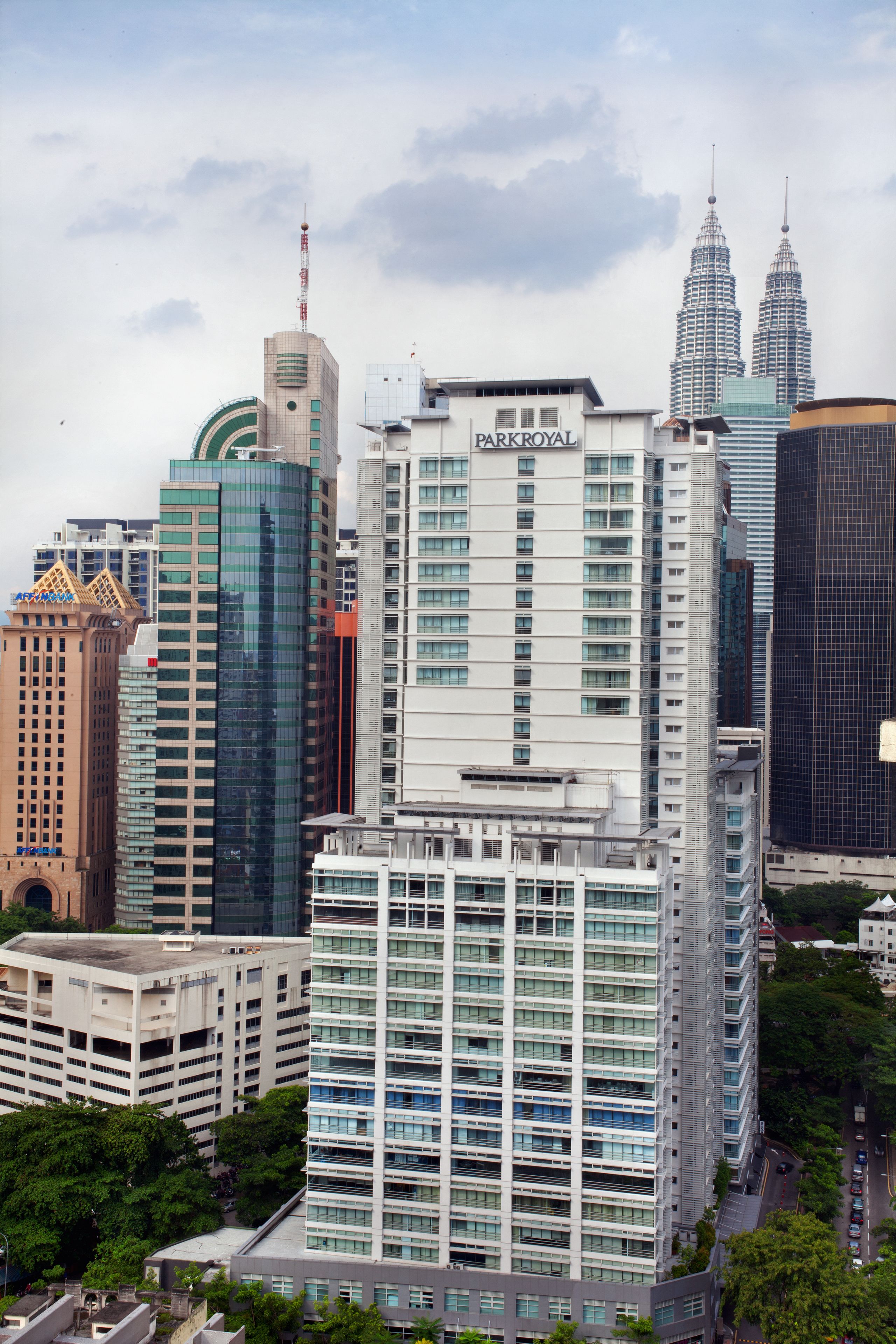 A high-rise building with a modern glass facade, surrounded by other tall buildings, including the iconic Petronas Towers.