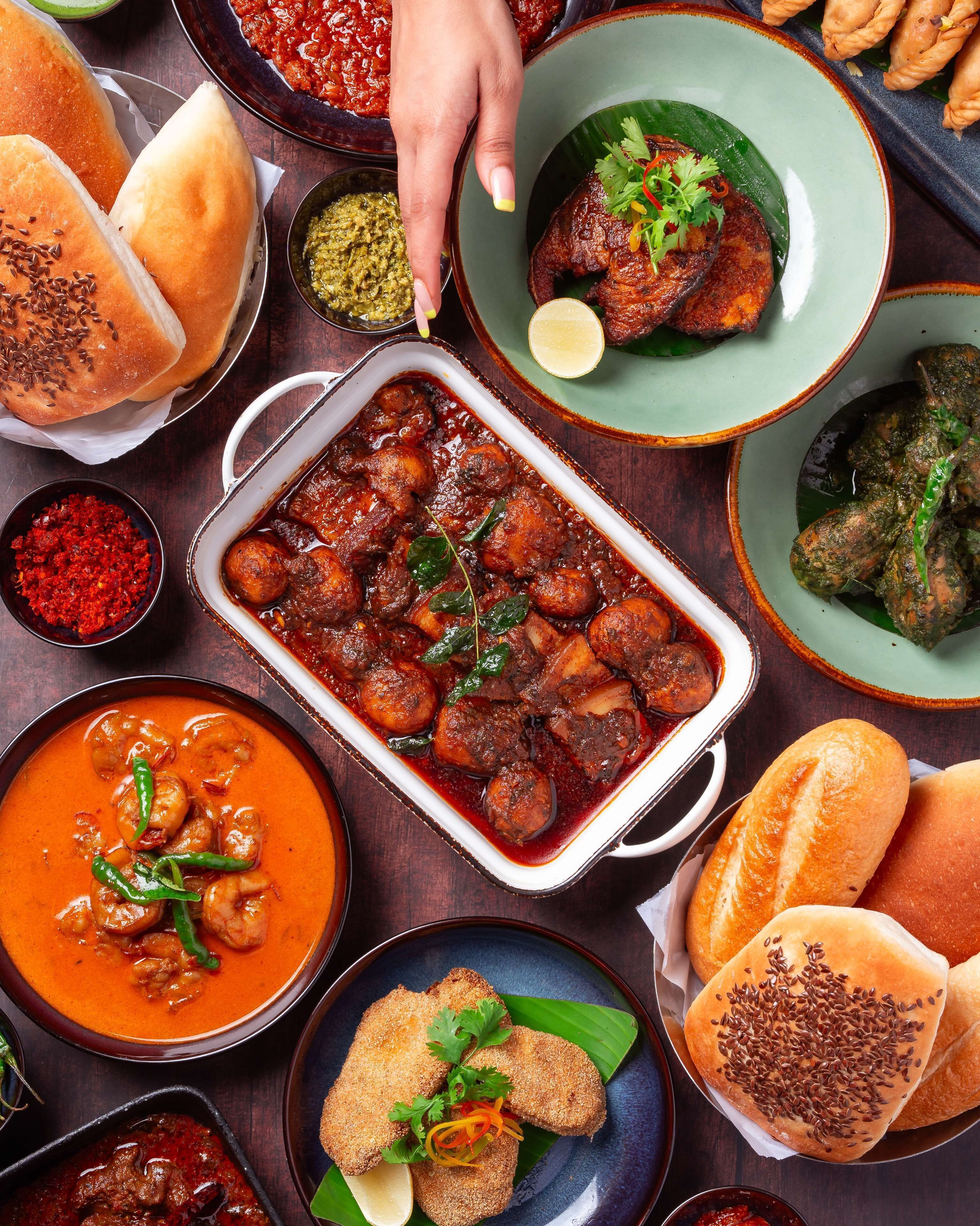 A variety of dishes including a baked dish, a bowl of soup, and several types of bread.