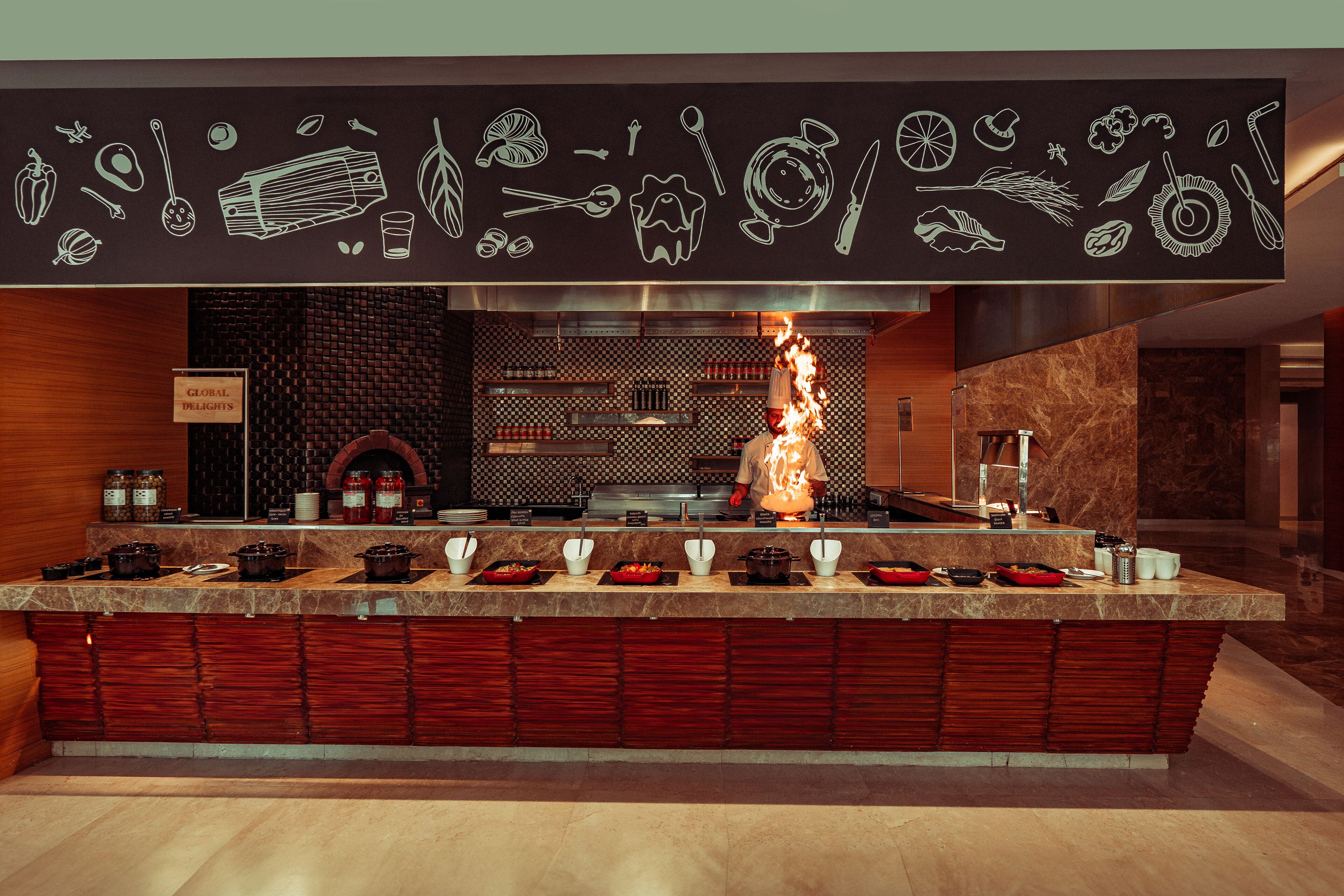 A modern kitchen with a chef cooking, a variety of cooking utensils, and a sign that reads "GLOBAL DELIGHTS".