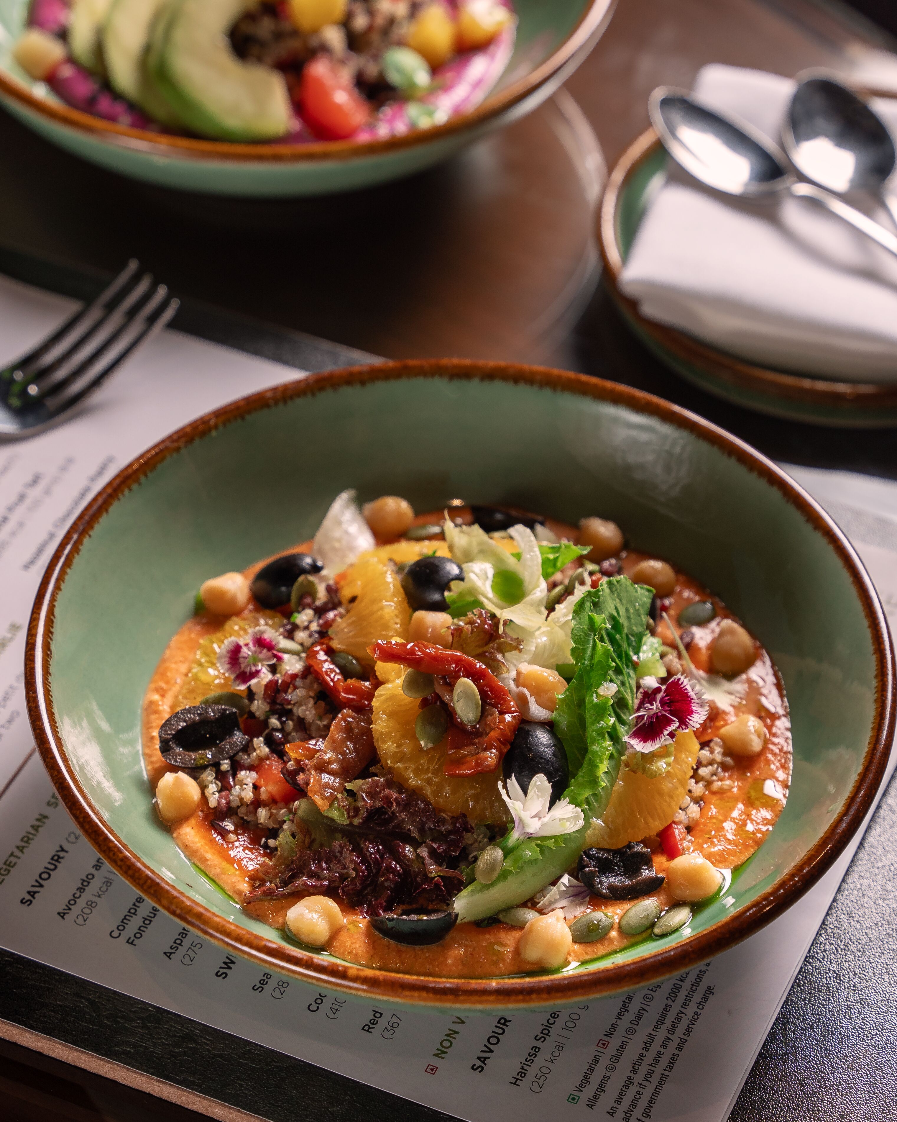 A bowl of food with various ingredients on a table.