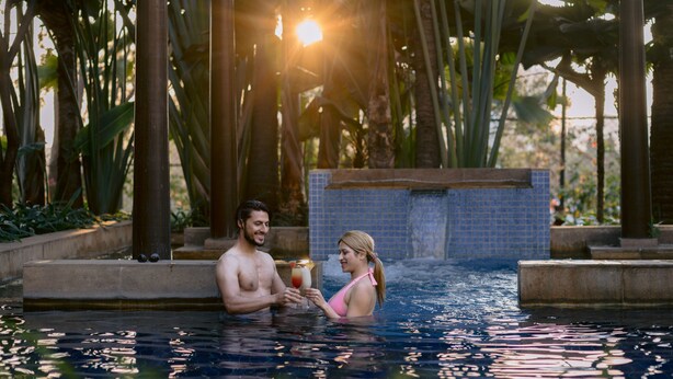 A couple in a pool with a tiled background and tropical plants. - Hyatt Pune (Pune)