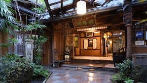 A traditional Japanese building with a tiled entrance, wooden beams, and a stone lantern. - Seikoro Ryokan (Kyoto)