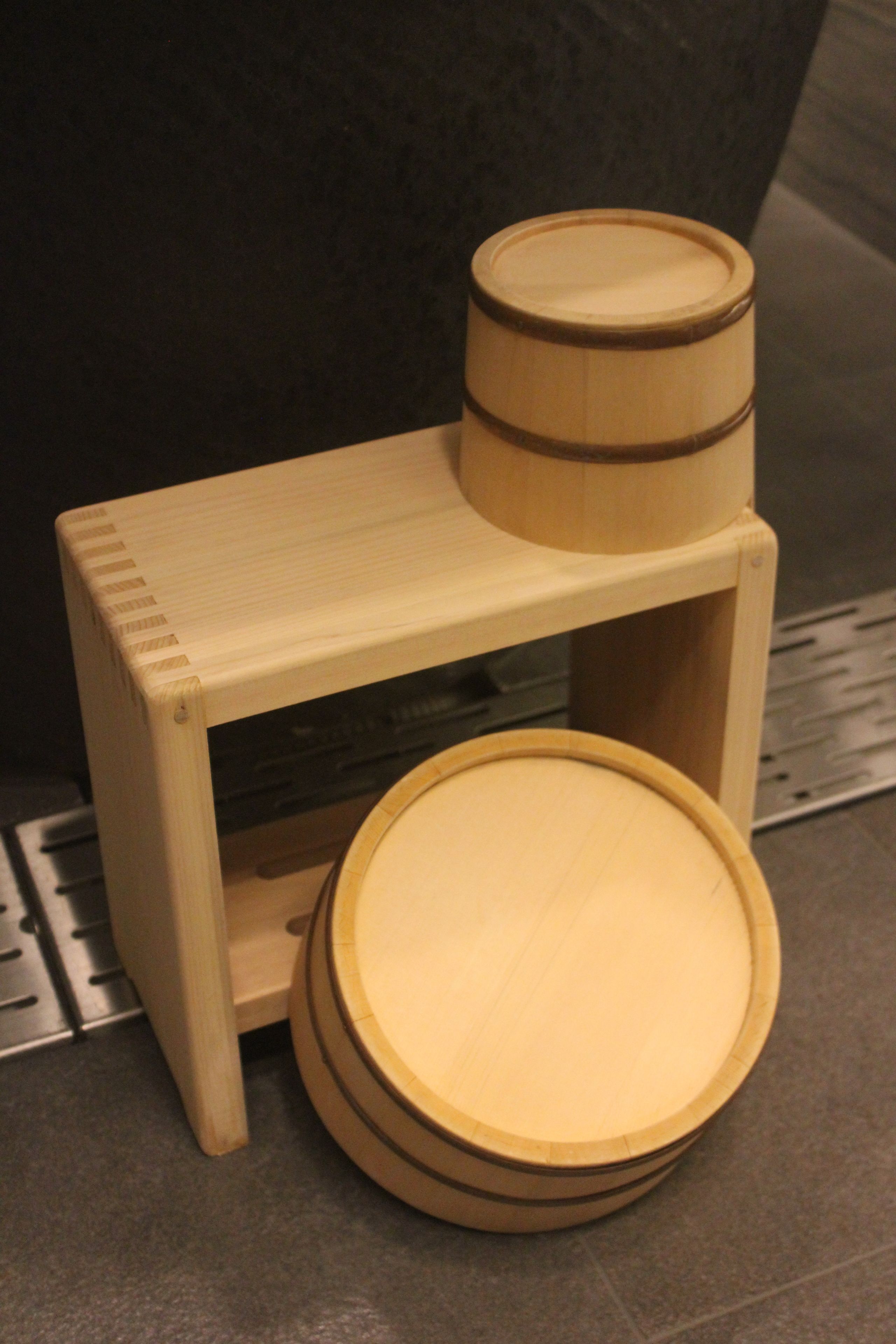 Un taburete de madera con asiento y base redondos.