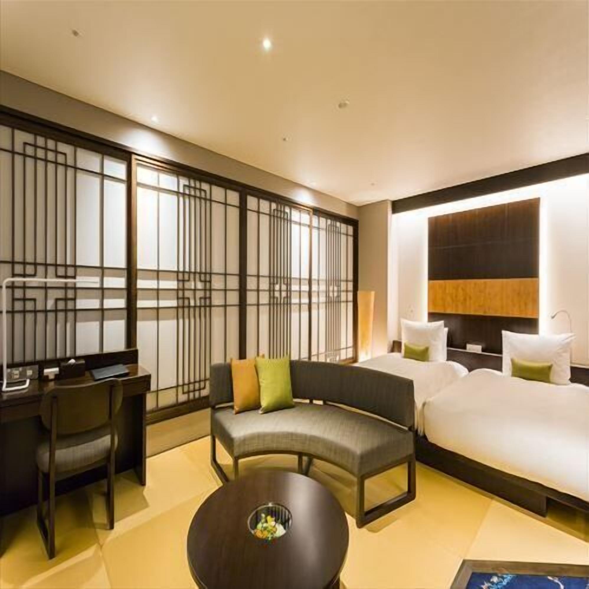 Une chambre d’hôtel avec un canapé, un lit, un bureau et une table ronde.