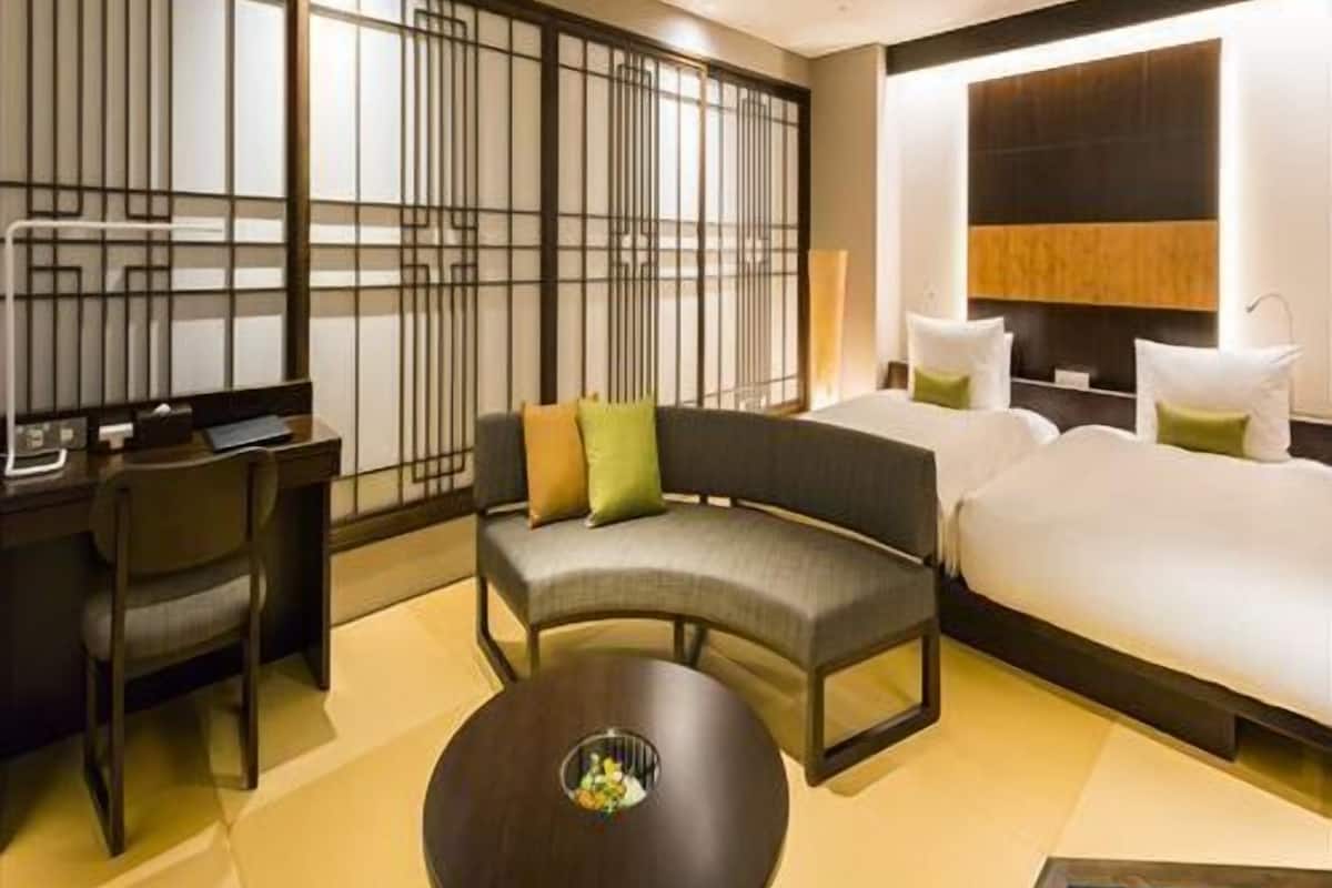 Une chambre d’hôtel avec un canapé, un lit, un bureau et une table ronde.